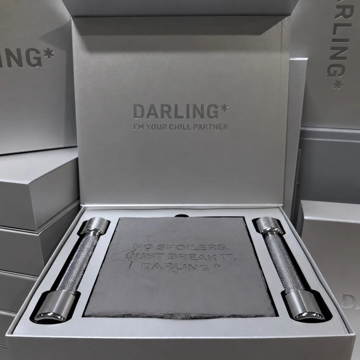Гипсовая плитка с надписью в коробке PR-набора Darling между двумя гантелями